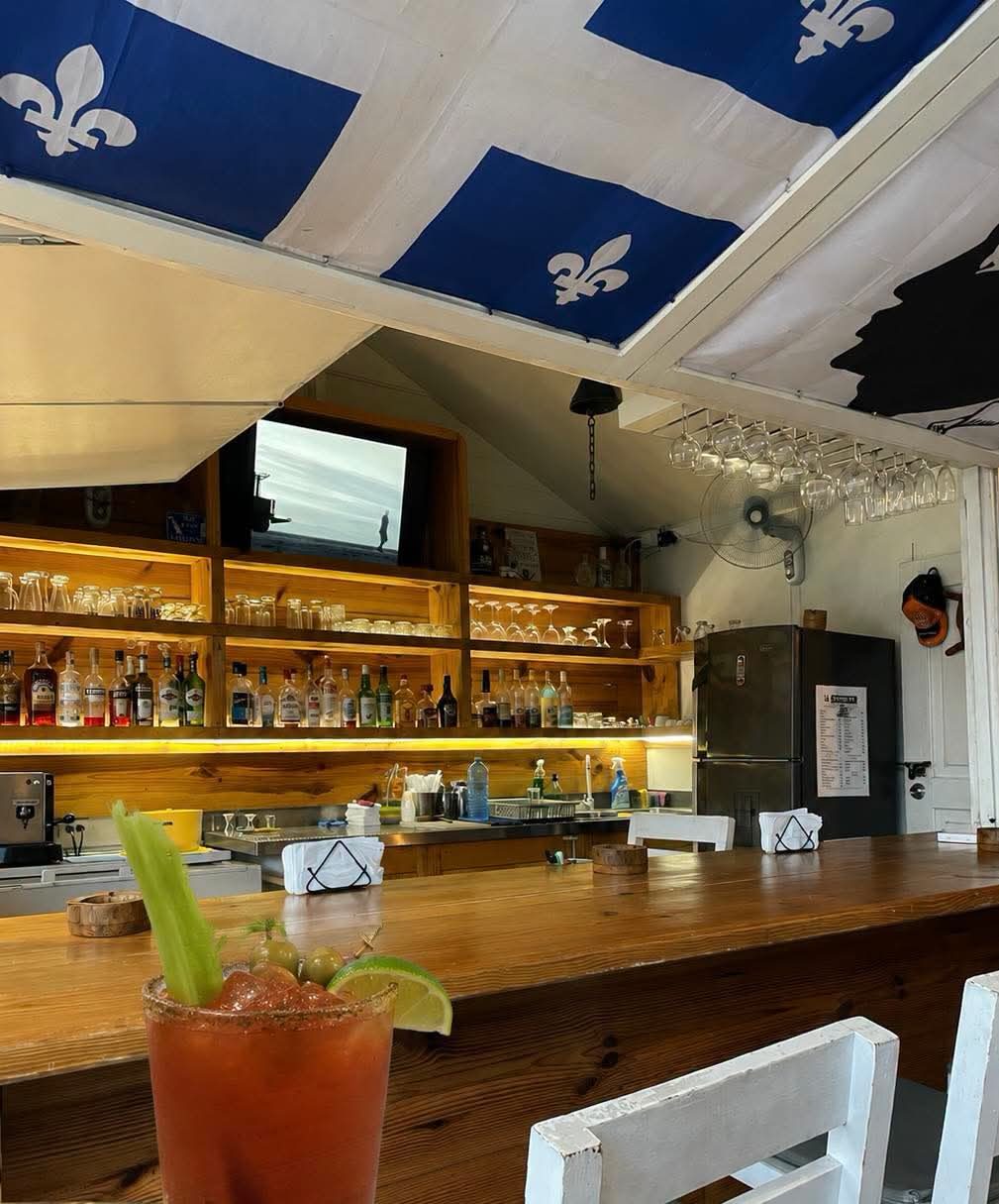 Sparrow's wooden bar under the Québec flag, with a Caesar in front