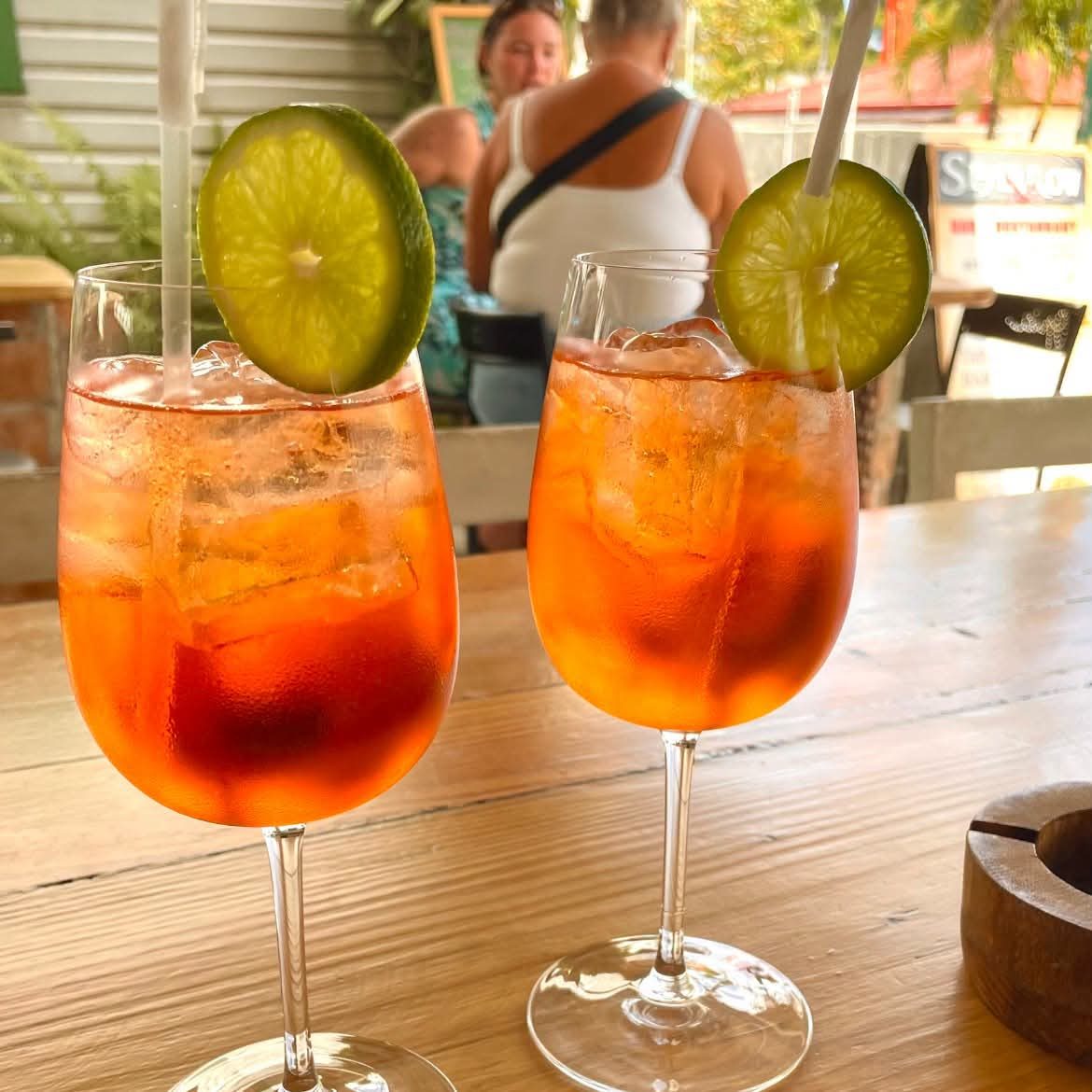 Two Aperol-style spritzes with lime